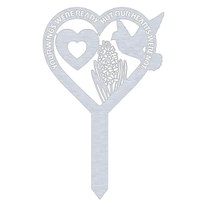 An aluminum grave marker with a heart-shaped top, featuring the phrase 'Your Wings Were Ready, But Our Hearts Were Not'. The design includes a heart outline, a detailed hummingbird, and floral engravings, all against a black background.